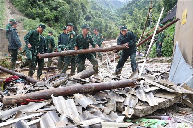 Bộ đội Biên phòng tỉnh Điện Biên giúp dân dọn dẹp nhà cửa bị đổ sập sau lũ quét. Ảnh: Phan Quân - TTXVN
