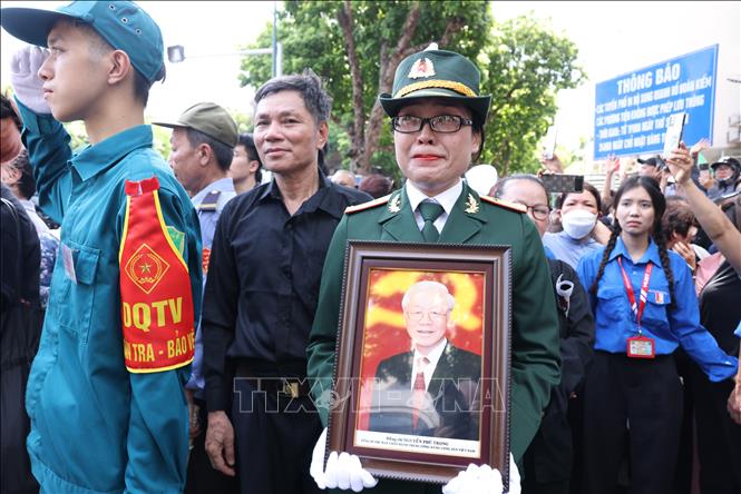 People pay their respect to Party leader Nguyen Phu Trong when his hearse passes by. VNA Photo