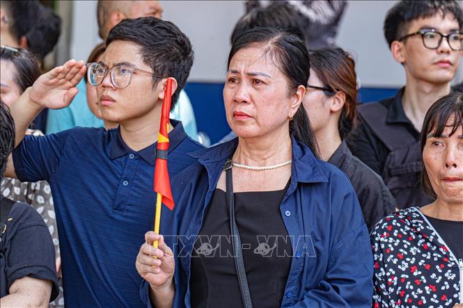 People pay their respect to Party leader Nguyen Phu Trong when his hearse passes by. VNA Photo