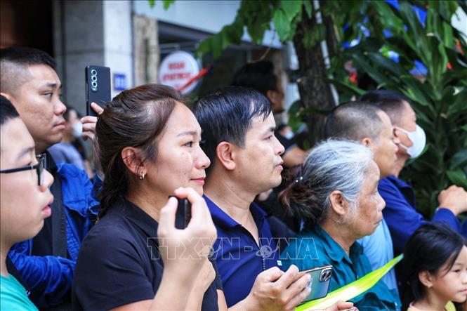 People pay their respect to Party leader Nguyen Phu Trong when his hearse passes by. VNA Photo