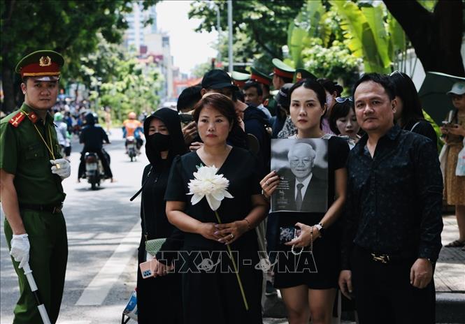 People pay their respect to Party leader Nguyen Phu Trong when his hearse passes by. VNA Photo