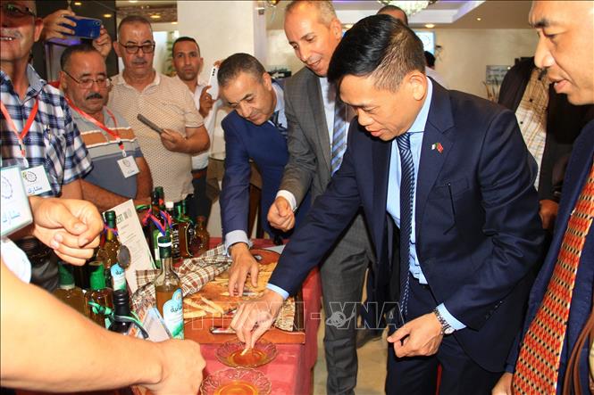 Đại sứ Trần Quốc Khánh dùng thử dầu ô liu, một sản phẩm thế mạnh và đạt nhiều giải thưởng quốc tế của các doanh nghiệp ở tỉnh Bordj Bou Arreridj. Ảnh: Trung Khánh - PV TTXVN tại Algeria