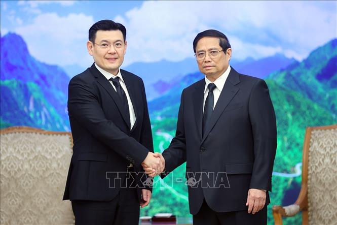 Prime Minister Pham Minh Chinh receives Minister Jakkapong Sangmanee. VNA Photo: Dương Giang