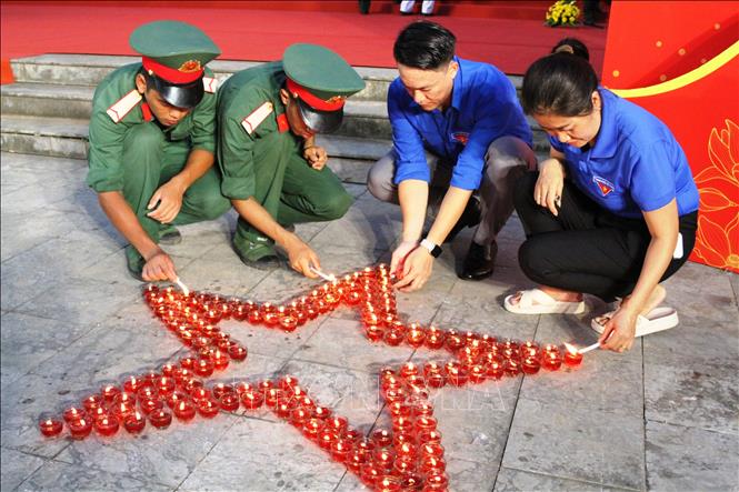 Đoàn viên thanh niên thắp nến tri ân các Anh hùng liệt sĩ tại Nghĩa trang liệt sĩ Độc Lập, tối 26/7/2024. Ảnh: Phan Quân - TTXVN