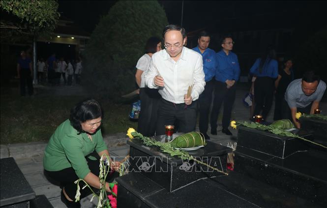 Các đại biểu thắp hương tưởng nhớ các liệt sĩ tại nghĩa trang; Ảnh: Vũ Hoàng Giang - TTXVN