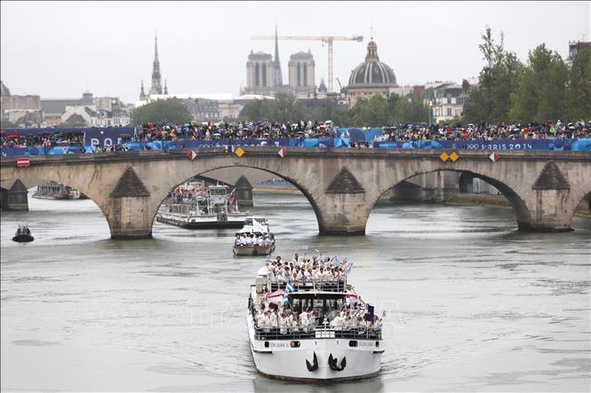 Thuyền chở các đoàn thể thao diễu hành trên sông Seine trong Lễ Khai mạc Olympic Paris 2024. Ảnh: THX/TTXVN