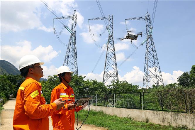 Workers of the Bao Loc Power Transmission Unit in the Central Highlands province of Lam Dong check the power line's operation by using drones with cameras. VNA Photo: Huy Hùng