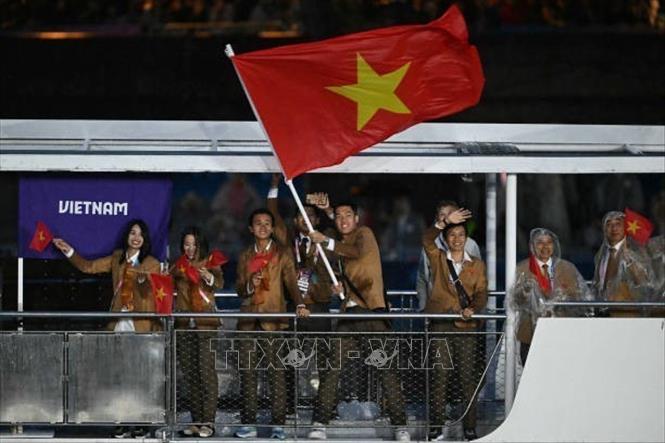 Đoàn thể thao Việt Nam diễu hành trên sông Seine trong Lễ Khai mạc Olympic Paris 2024. Ảnh: Getty Images/TTXVN