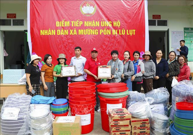 Các tổ chức, cá nhân hỗ trợ nhu yếu phẩm, vật dụng sinh hoạt cho người dân vùng lũ Mường Pồn. Ảnh: Xuân Tư - TTXVN
