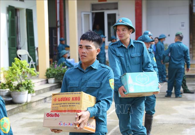 Lực lượng dân quân chuẩn bị lượng thực, nước uống vận chuyển đến với người dân vùng lũ Mường Pồn. Ảnh: Xuân Tư – TTXVN