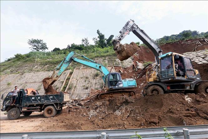 Máy xúc, ô tô được huy động để xúc, ủi, san gạt đảm bảo thông tuyến nhanh nhất. Ảnh: Quang Quyết- TTXVN