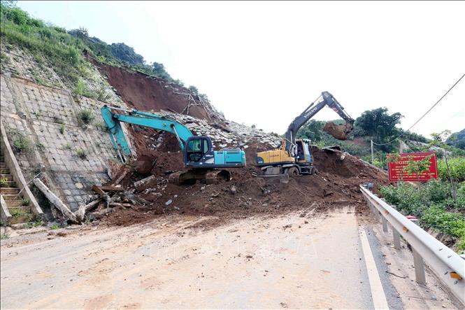 Máy xúc, ô tô được huy động để xúc, ủi, san gạt đảm bảo thông tuyến nhanh nhất. Ảnh: Quang Quyết- TTXVN