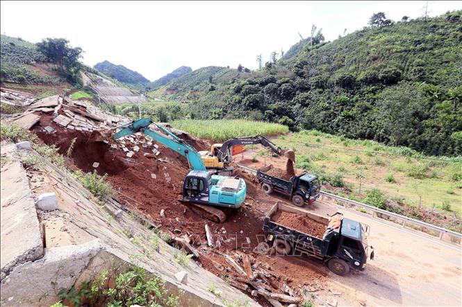 Máy xúc, ô tô được huy động để xúc, ủi, san gạt, đảm bảo thông tuyến nhanh nhất. Ảnh: Quang Quyết- TTXVN