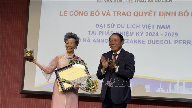 Minister Nguyen Van Hung presents a decision reappointing Anoa Suzzanne Dussol Perran, a French national, as Vietnam's Tourism Ambassador to France for the 2024-2029 tenure. VNA Photo: Nguyễn Tuyên 