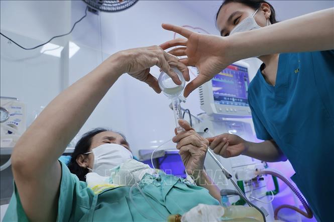A healthcare worker supports a newborn drinking breast milk from the human milk bank at Da Nang Hospital for Women and Children. VNA Photo: Minh Quyết