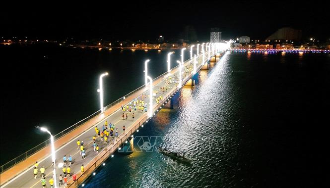 Các vận động viên tham gia giải chạy qua cầu Nhật Lệ 1, thành phố Đồng Hới, Quảng Bình từ sáng sớm 28/7. Ảnh: TTXVN phát