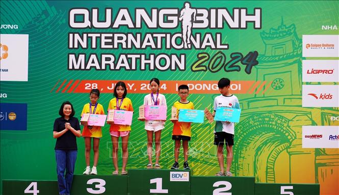 Bà Nguyễn Minh Tâm, Phó Trưởng đoàn chuyên trách Đoàn ĐBQH tỉnh Quảng Bình trao giải thưởng cho các vận động nhỏ tuổi có thành tích xuất sắc ở cự ly 5km. Ảnh: TTXVN phát