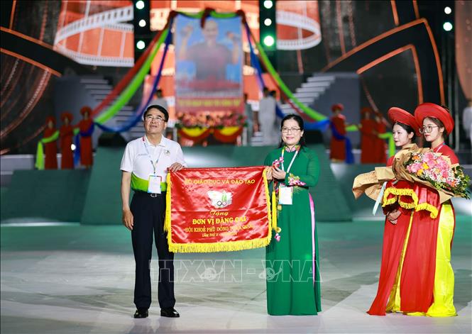 Thứ trưởng Bộ GD&ĐT Nguyễn Thị Kim Chi trao cờ đăng cai Hội khỏe Phù Đổng toàn quốc lần thứ 10 cho Phó Chủ tịch UBND thành phố Hải Phòng Lê Khắc Nam. Ảnh: Thanh Tùng - TTXVN