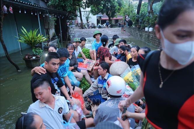 Người dân thôn Nam Hài phải di chuyển bằng thuyền từ 24/7 đến nay do các tuyến đường đều bị ngập nặng. Ảnh: Hoàng Hiếu - TTXVN