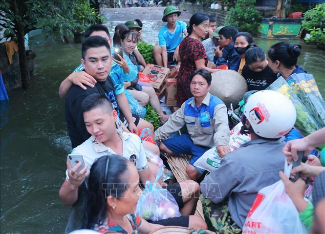 Người dân thôn Nam Hài phải di chuyển bằng thuyền từ 24/7 đến nay do các tuyến đường đều bị ngập nặng. Ảnh: Hoàng Hiếu - TTXVN