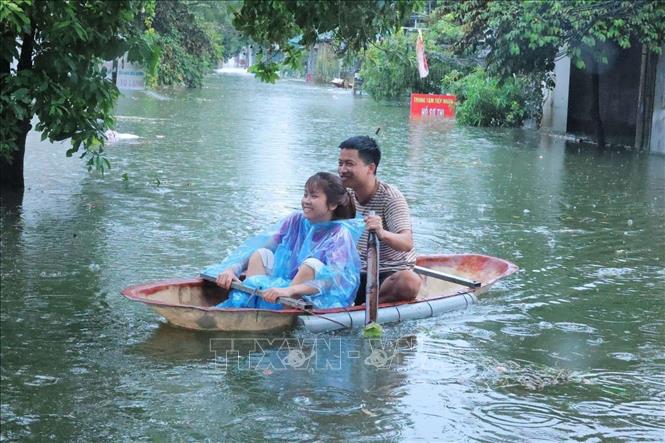 Người dân làng Hạnh Bồ phải di chuyển bằng thuyền do nước ngập khoảng 1,5m. ảnh: Hoàng Hiếu - TTXVN