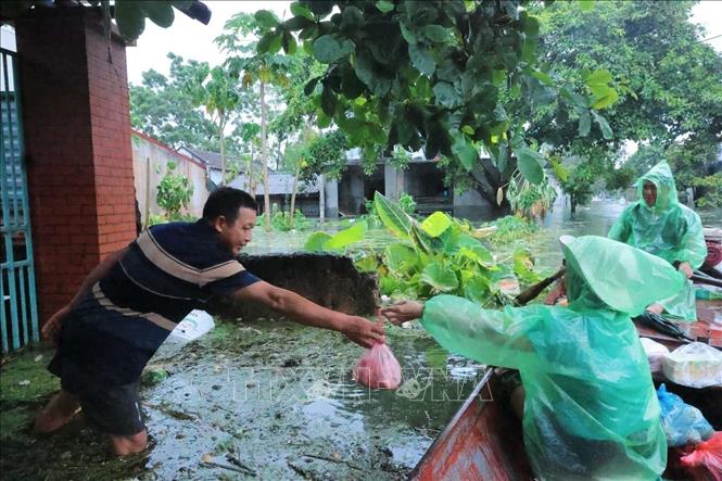 Người dân thôn Hạnh Bồ nhận đồ tiếp tế do nước ngập sâu khó di chuyển. Ảnh: Hoàng Hiếu - TTXVN