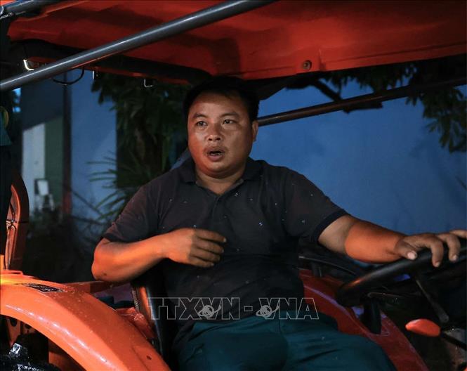 Anh Bùi Ngọc Bình, Trưởng thôn Nam Hài đã dùng phương tiện cá nhân giúp bà con chạy ngập, chuyển đồ đạc cần thiết, di chuyển trong thôn ra ngoài và ngược lại. Ảnh: Hoàng Hiếu - TTXVN