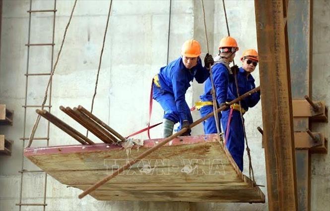 Công nhân thi công trên những trụ của dự án cầu Lạc Quần. Ảnh: Thái Thuần - TTXVN