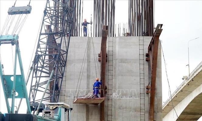 Công nhân thi công trụ cầu cạn cầu Lạc Quần. Ảnh: Thái Thuần - TTXVN