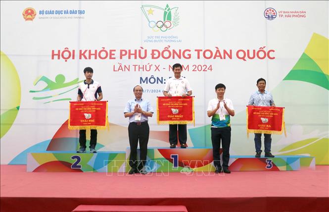 Ban tổ chức trao cờ cho các đội nhất, nhì và ba toàn đoàn tại môn Bơi, Hội khỏe Phù Đổng toàn quốc lần thứ X. Ảnh: Hoàng Ngọc - TTXVN