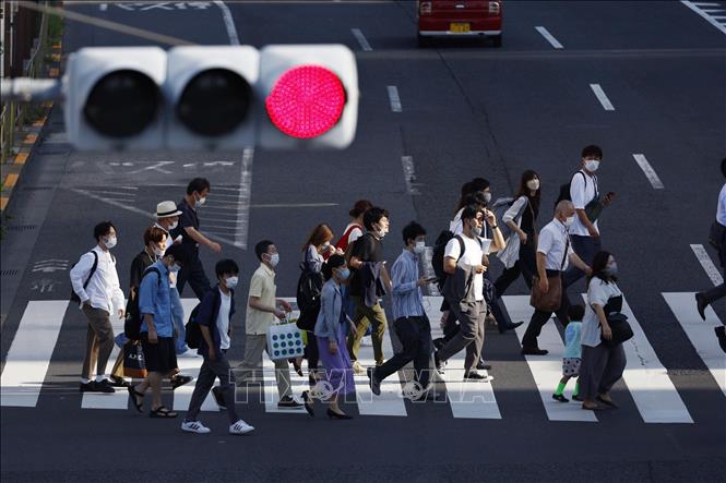 Người đi làm hàng ngày di chuyển tại nhà ga JR Shinagawa ở Tokyo, Nhật Bản. Ảnh: Kyodo/TTXVN