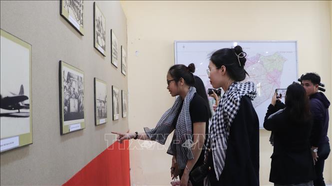 Du khách tìm hiểu các hình ảnh lịch sử tại Di tích lịch sử Trụ sở Ủy ban liên hợp đình chiến Nam Bộ. Ảnh: Hồng Thái - TTXVN