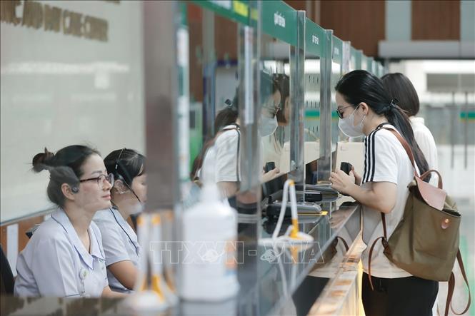 Người dân đến khám bệnh đăng ký tại quầy tiếp đón. Ảnh: Minh Quyết - TTXVN