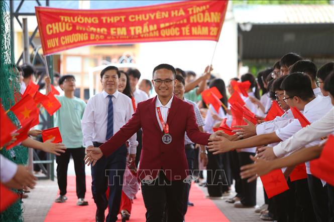 Thầy cô và bạn bè đón Trần Minh Hoàng tại trường THPT Chuyên Hà Tĩnh. Ảnh: Hoàng Ngà - TTXVN