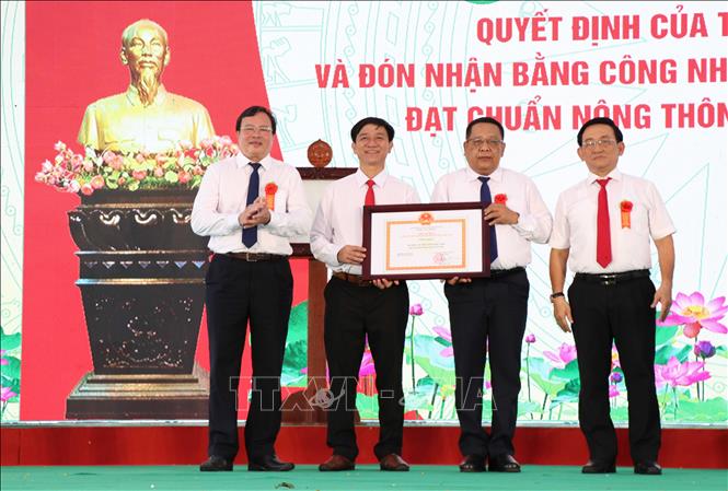 Lãnh đạo huyện Cầu Kè đón nhận Bằng công nhận đạt chuẩn Nông thôn mới nâng cao. Ảnh: Thanh Hòa - TTXVN