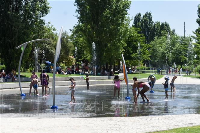 Người dân tránh nóng bên đài phun nước tại Madrid, Tây Ban Nha, ngày 4/7/2024. Ảnh: THX/TTXVN