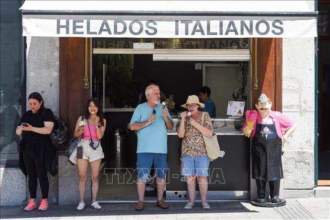 Người dân ăn kem giải nhiệt tại Madrid, Tây Ban Nha, ngày 4/7/2024. Ảnh: THX/TTXVN