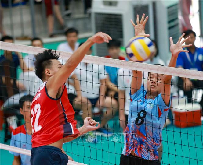Một pha bóng lên lưới trong trận đấu giữa đội Quảng Trị (áo xanh) và đội Hòa Bình (áo đỏ). Ảnh: Thanh Tùng - TTXVN