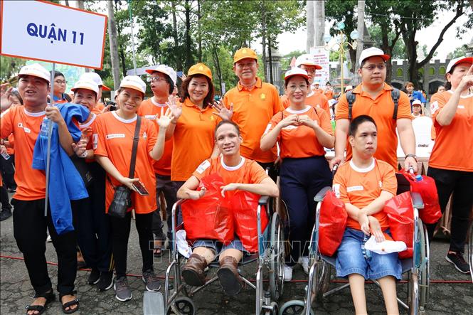 Lãnh đạo Sở Lao động, Thương binh và Xã hội Thành phố Hồ Chí Minh trao quà cho các em là nạn nhân da cam. Ảnh: Thanh Vũ-TTXVN
