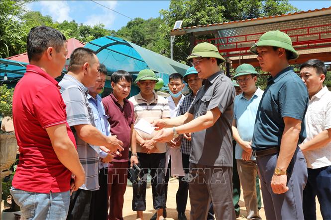 Phó Chủ tịch Thường trực UBND tỉnh Lạng Sơn Dương Xuân Huyên trao tiền hỗ trợ cho người thân gia đình gặp nạn. Ảnh: Văn Đạt - TTXVN