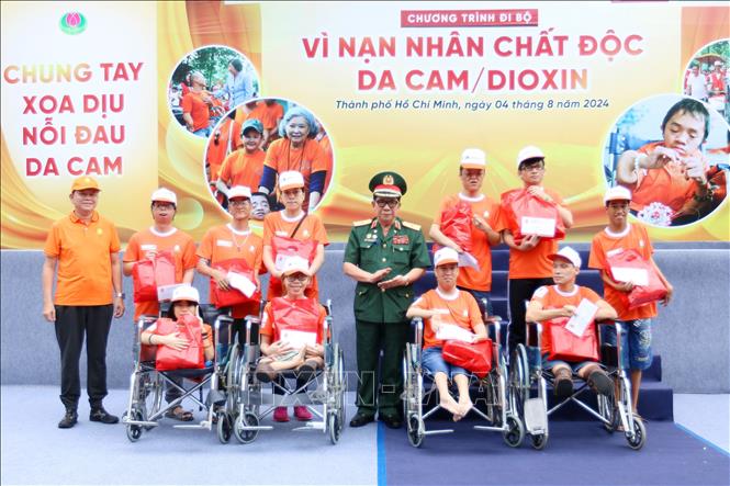 Thiếu tướng Trần Ngọc Thổ, Chủ tịch Hội nạn nhân chất độc da cam/dioxin Thành phố Hồ Chí Minh trao quà cho các em là nạn nhân da cam. Ảnh: Thanh Vũ-TTXVN
