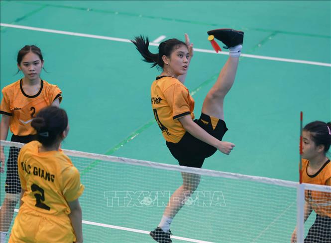 Thi đấu chung kết môn đá cầu, nội dung đồng đội nữ giữa Đồng Tháp (áo vàng đậm) và Bắc Giang (áo vàng nhạt). Ảnh: Thanh Tùng - TTXVN
