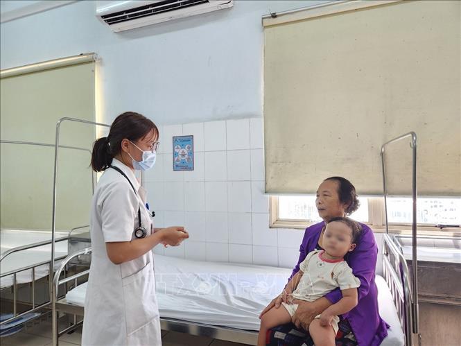 Bác sĩ dặn dò người nhà cách chăm sóc bệnh nhi. Ảnh: Mai Trang- TTXVN 