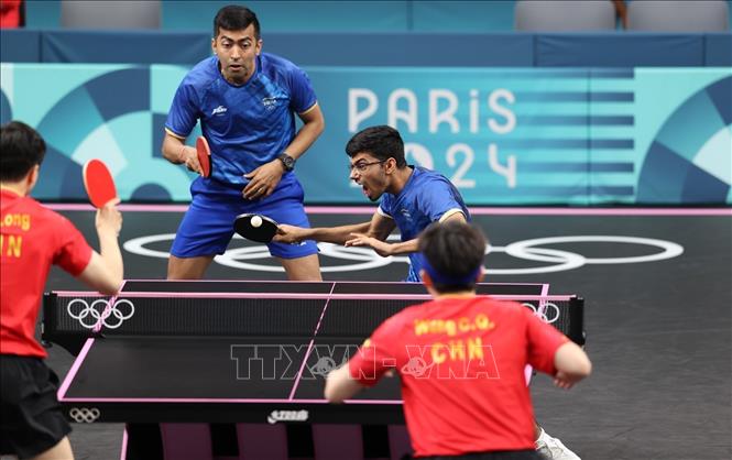 Cây vợt Thakkar Manav Vikash của Ấn Độ đang nỗ lực thực hiện cú đánh ở nội dung đánh đôi đầu tiên giữa 2 đội, bên trái anh là đồng đội Desai Harmeet. Ảnh: Hoàng Linh - phóng viên TTXVN tại Paris