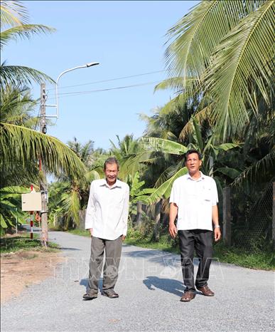 Gia đình ông Phạm Văn Rực (bên trái), xã Long Đức, thành phố Trà Vinh hiến gần 1.000m2 đất để làm đường xây dựng nông thôn mới. Ảnh: Thanh Hòa - TTXVN