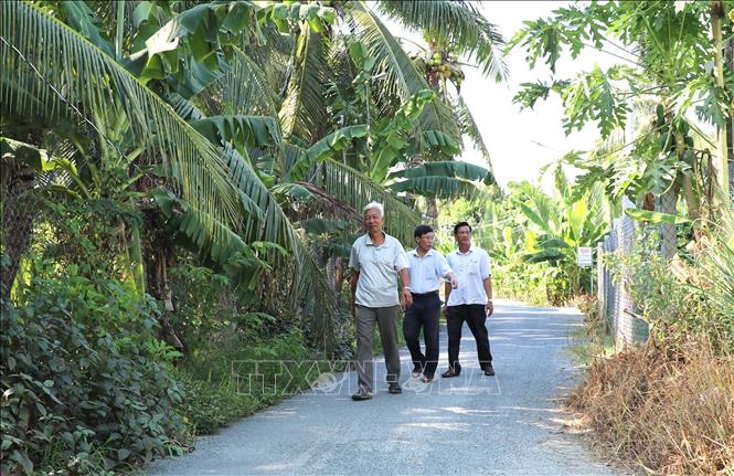 Ông Huỳnh Văn Triều (đi trước), ấp Công Thiện Hùng, xã Long Đức, thành phố Trà Vinh đã hiến hơn 600m2 đất để làm đường nông thông thôn. Ảnh: Thanh Hòa - TTXVN