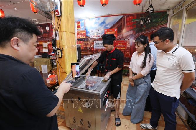 Đại diện Trung tâm xúc tiến Đầu tư, Thương mại và Du lịch Lạng Sơn và chuyên gia ẩm thực Nguyễn Thường Quân khảo sát quy trình đóng gói sản phẩm vịt quay tại cơ sở Vịt quay Hồng Xiêm. Ảnh: Anh Tuấn – TTXVN