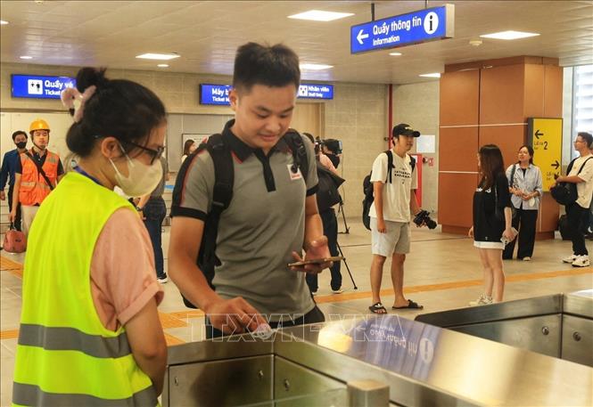 Hành khách quẹt thẻ qua cửa để lên tàu. Ảnh: Tuấn Anh - TTXVN