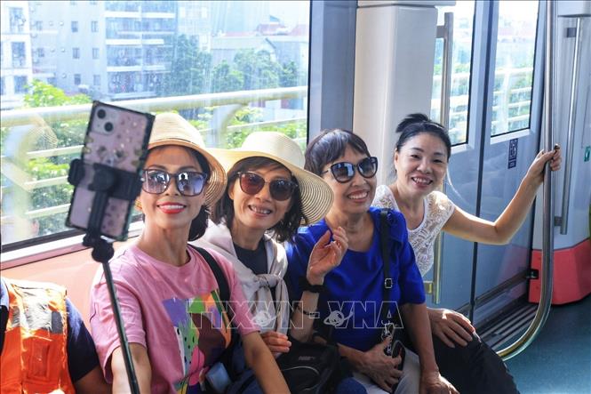 Hành khách ghi lại khoảnh khắc lần đầu tiên được đi tàu điện trên cao. Ảnh: Tuấn Anh - TTXVN