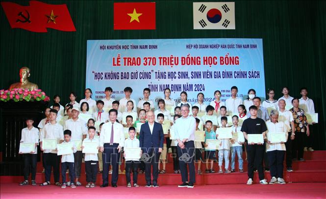 Trao học bổng cho học sinh, sinh viên là con em gia đình có công với cách mạng. Ảnh: Nguyễn Lành - TTXVN